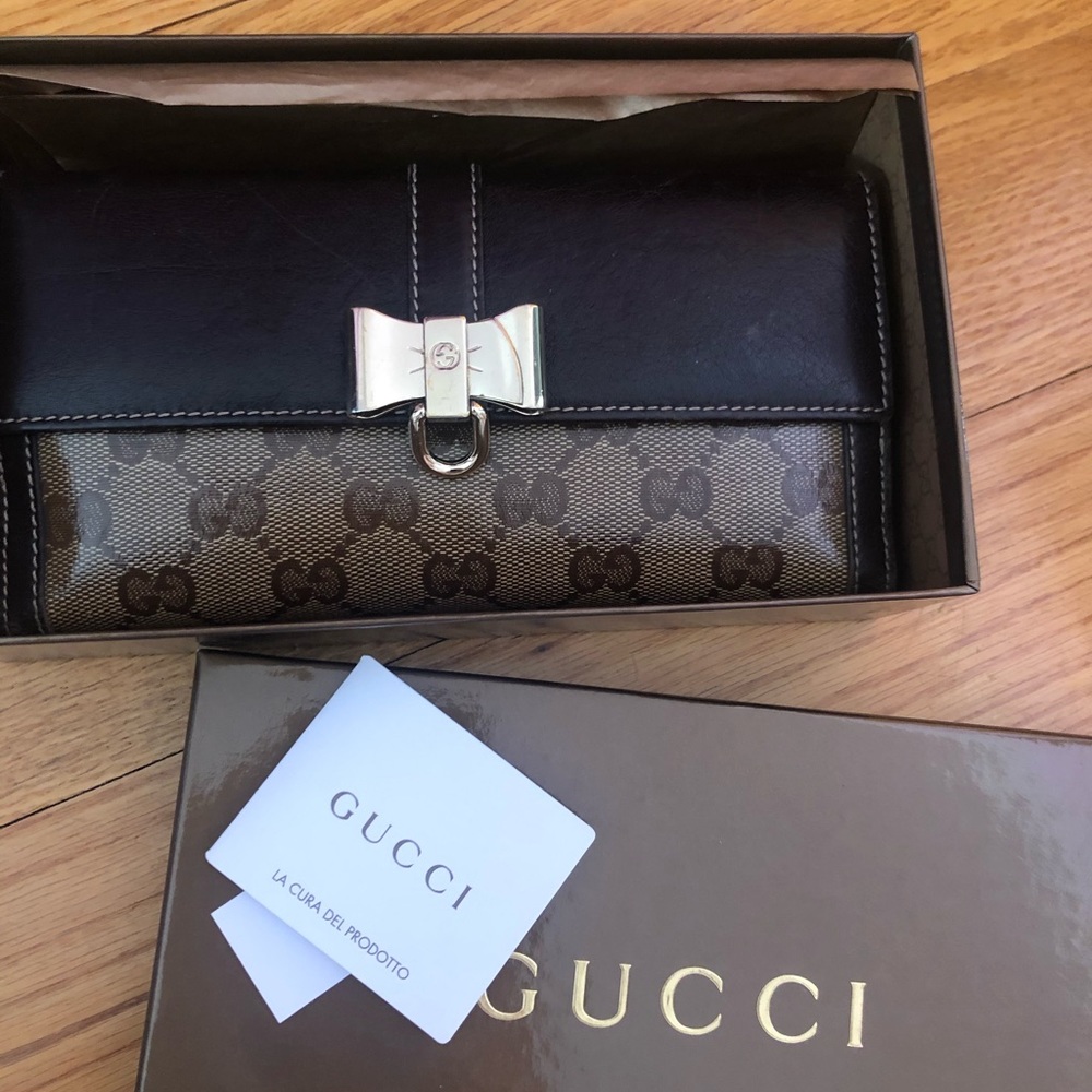 Monogram GG Gucci flap wallet with gold bow